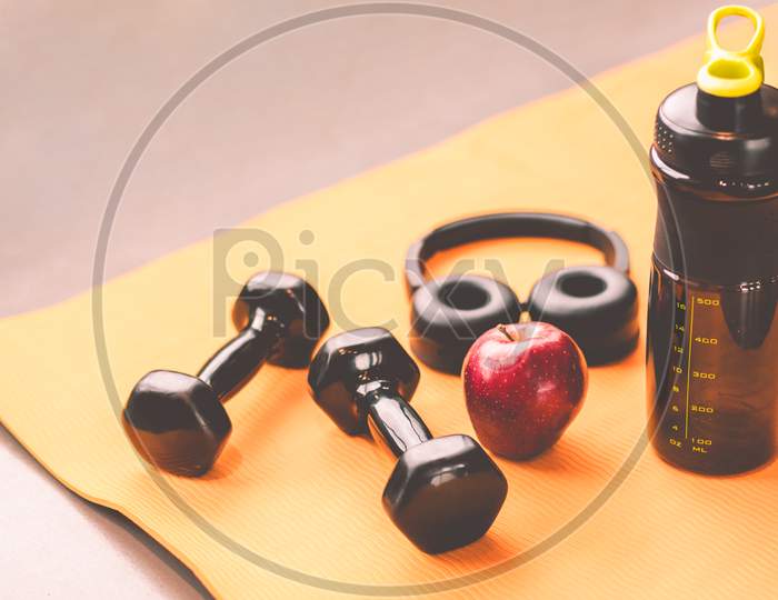 Exercise Workout Equipment With Dumbbell At Gym Fitness Sport Training Center. Headphone Apple Fruit And Protein Shake Bottle. Health And Lifestyle Relax Bodybuilding And Diet Weight Lose Prop Concept