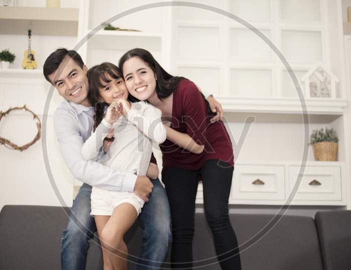 Three Happy Family'S Members In Happy Mood With Hug, Smiling Togetherm Mom, Dad And Daughter Acting Ing Happiness Concept
