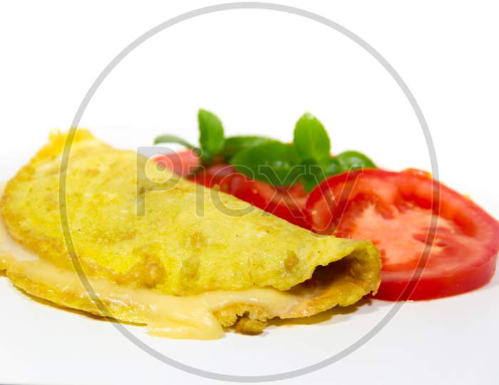 Omelette Made With Beaten Eggs Stuffed With Onion Cheese And Tomatoes On White Background With Sliced Tomatoes And Basil