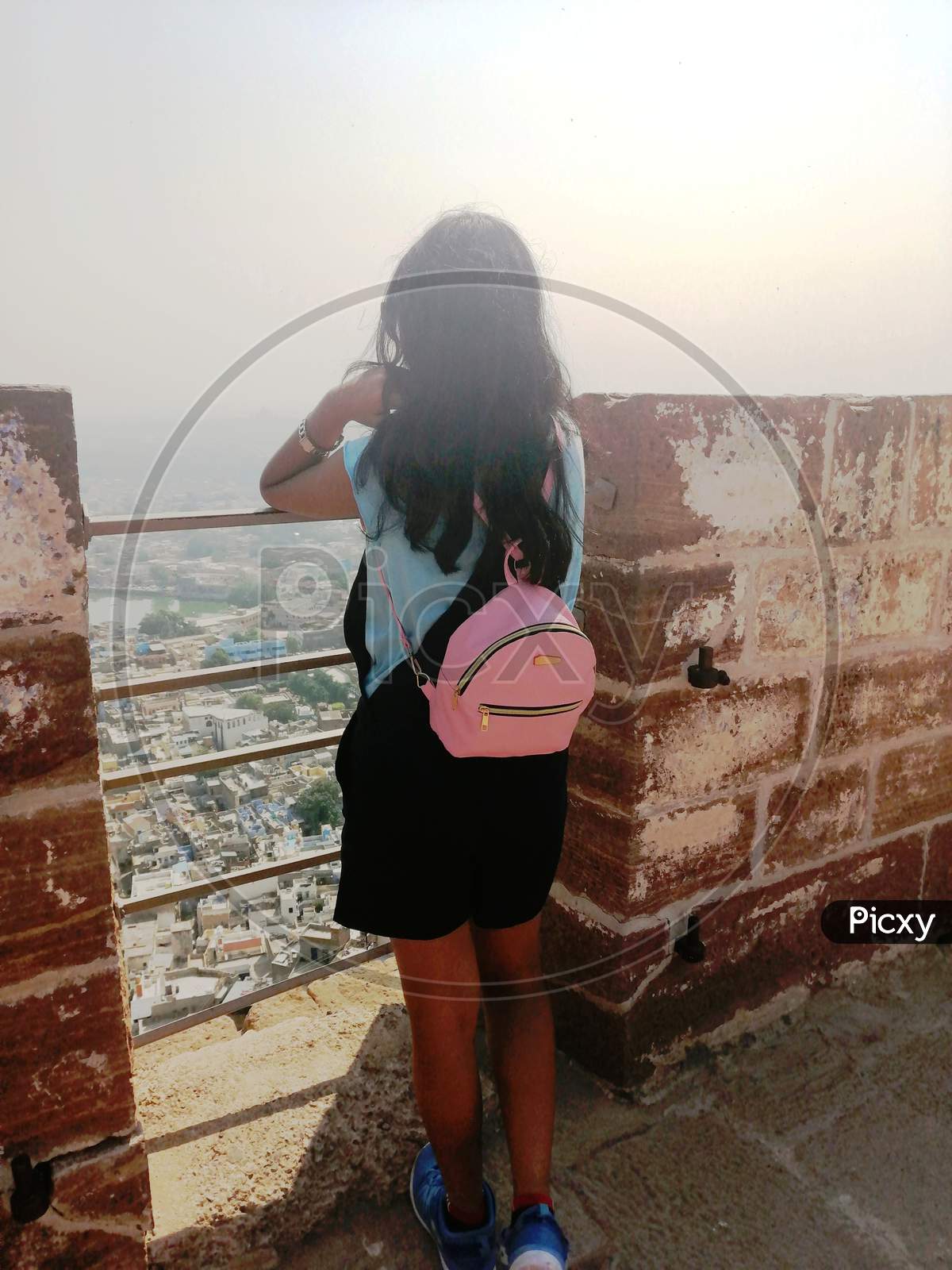 a tourist girl overlooking the city of Jodhpur from the Mehrangarh fort