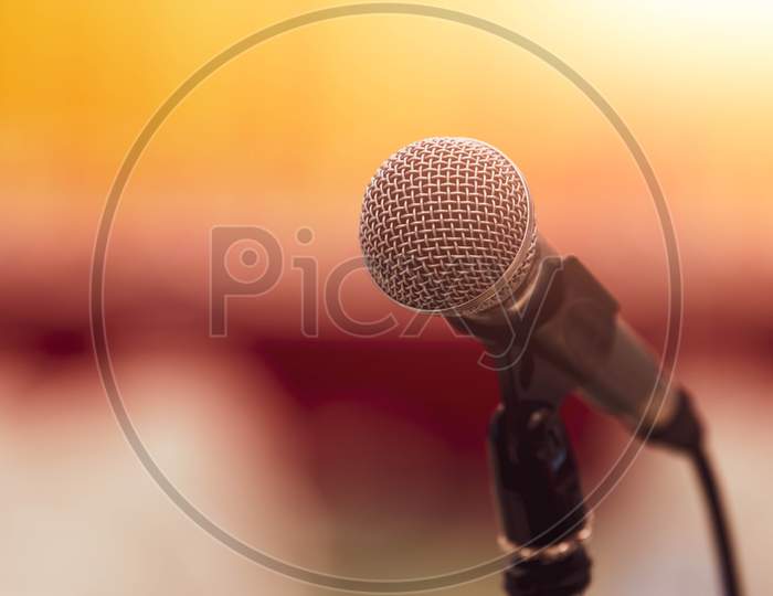 Closeup Of Microphone On Abstract Blurred Background Speech In Seminar Convention Hall Room And Light As Guest And Conference Speaker On Podium. Workshop Event And Entertainment Broadcast Concept