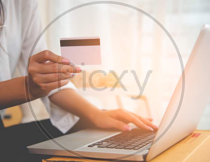 Close Up Hand Of Woman Using Credit Card For Online Shopping Payment With Laptop Computer. Technology And Business Concept.
