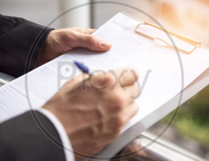 Businessman Is Signing At The Sign Paper, Business Agreement Concept, Selective Focus On Left Heand