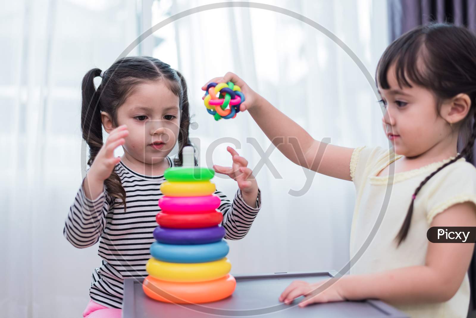 Two Little Girls Playing Small Toy Balls In Home Together. Education And Happiness Lifestyle Concept. Funny Learning And Children Development Theme. Smile Faces