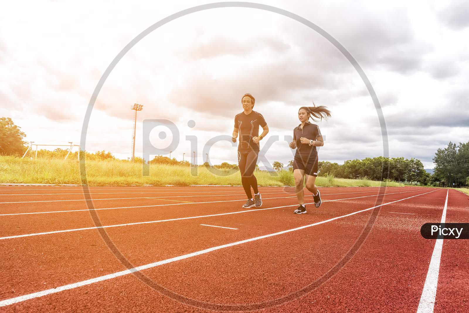 Two Runners Jogging On The Race Track, Sport And Social Activity Concept