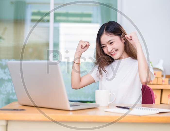 Asian Woman Enjoy Herself While Using Laptops And Internet In Office. Business And Marketing And Part Time Concept. On Line Shopping And Business Success Theme. Happy Mood When Finished Working Job.