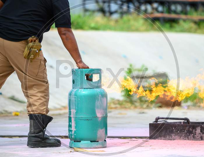 Closeup Of Firefighters Lower Body Training For Fire Drill By Demonstrate How To Close The Gas Tank Valve Correctly. Security Insurance Protection And Fire Fighter Concept. Occupation And Volunteer
