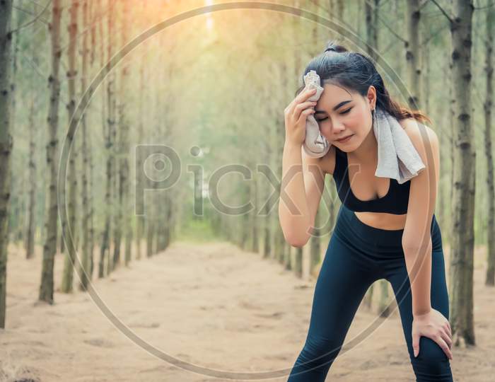 Asian Beauty Woman Wiping The Sweat In Forest. Towel And Sweat Elements. Sport And Healthy Concept. Jogging And Running Concept. Relax And Take A Break Theme. Outdoors Activity Theme.