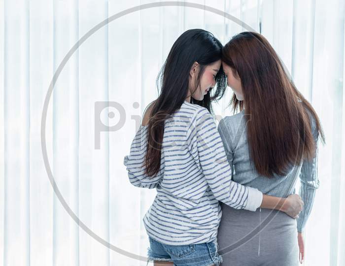 Two Asian Lesbian Women Looking Together In Bedroom. Couple People And Beauty Concept. Happy Lifestyles And Home Sweet Home Theme. Embracing Of Homosexual. Love Scene Making Of Female. Back View Angle