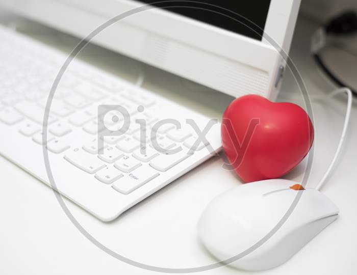 Red Heart In Office With Computer Desk Set. Mini And Small Size Of Sponge Heart For Muscle Relaxant In Hospital. Dating And Flirting Concept. Valentines Day And Love Theme. Keyboard And Mouse Elements