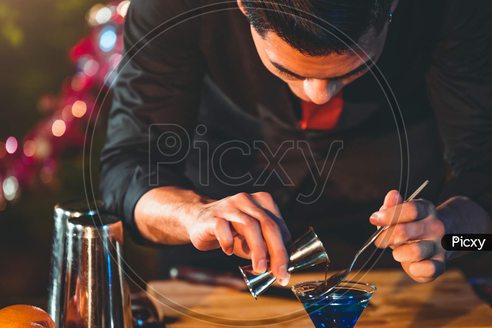 Professional Bartender Preparing Fresh Juice Cocktail In Drinking Wine Glass With Ice At Night Bar Clubbing Counter. Occupation And People Lifestyles Concept. Outdoor And Nightclub Background