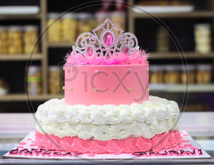 pink cake with icing on top and decorations