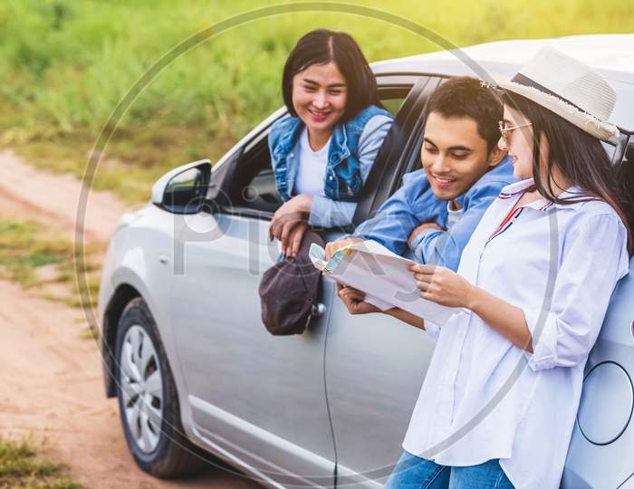 Happy Asian Woman And Her Friends Standing By Car On Coastal Road At Sunset. Young Girl Having Fun During Road Trip. People Lifestyles And Travel Vacation Concept. Friendship Journey And Outdoor Tour
