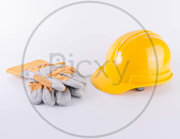 Yellow Safety Helmet And Safety Gloves On White Background. Hard Hat And Thick Gloves On White Isolated Background. Safety Equipment Concept. Worker And Industrial Theme.