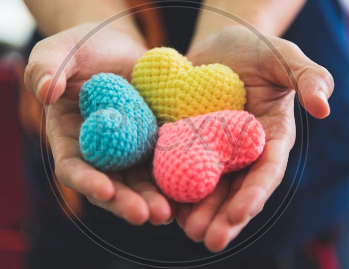 Close Up Hands Giving Colorful Yarn Heart Handmade. Valentine Day Of Love Concept. Medical Ventilator And Heart Donator Charity. Sign Of Compassion And Healthy. Helping Hand In Romantic Happiness Life