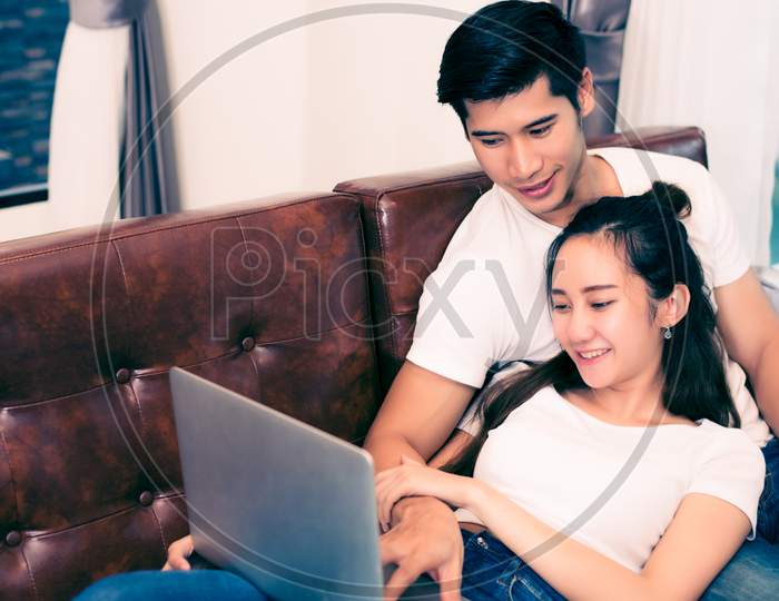 Asian Young Couples Using Laptop. Lovers And Couples Concept. Honeymoon And Wedding Theme. Interior And Dating Theme.