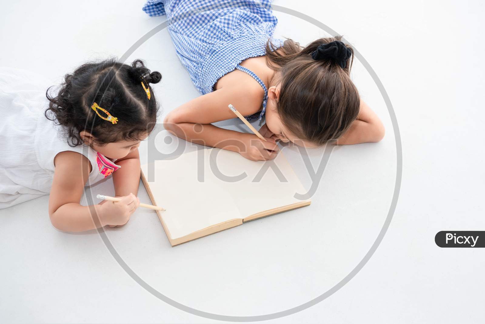 Top View Of Happy Two Sister Drawing In Sketch Book Together At Home Or Nursery. People Lifestyle And Kids Play. Education And Children Concept. Diverse Ethnicity And Ages. Back To School Theme