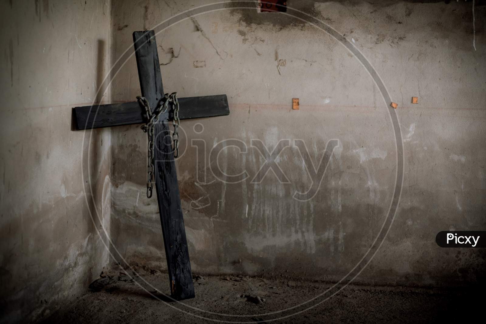 Black Crucifix Against Wall With Hanging Steel Chain And Gun. Halloween Day Party Festival Celebration. Ancient Sign Of Religion Concept. Dark And Scary Tone