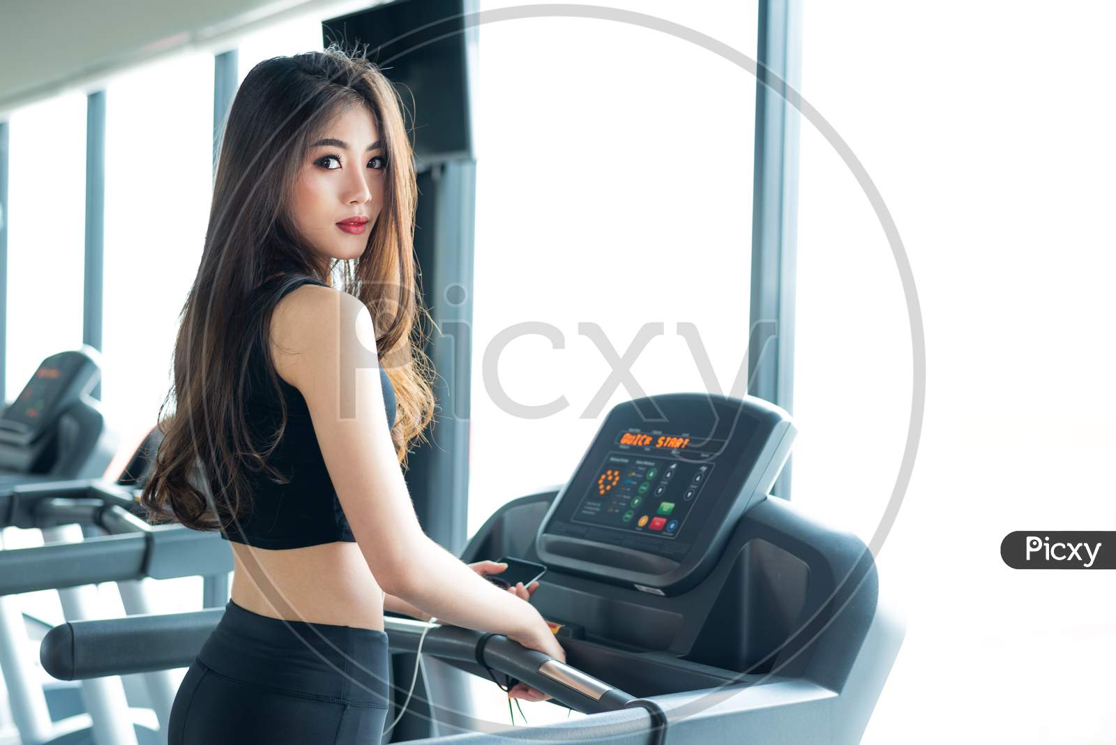 Asian Sport Woman Walking Or Running On Treadmill Equipment In Fitness Workout Gym. Sport And Beauty Concept. Workout And Strength Training Theme. Cardio And Diet Theme. Woman Portrait