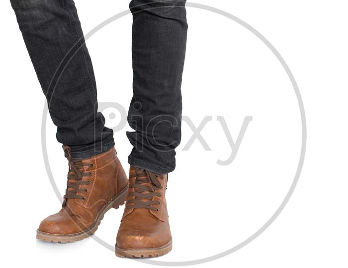 Lower Half Of Man Leg And Foot Wearing Jeans And Shoes On Isolated White Background. Fashion And People Concept. Parts Of Body Theme.