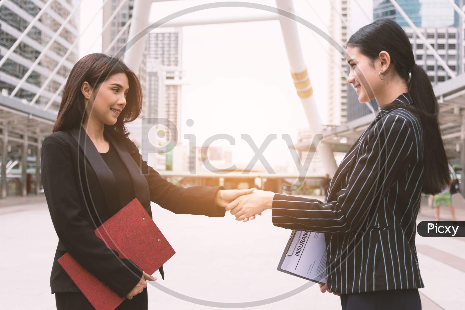 Two Women Making Handshake Greeting Each Other In Group Meeting At Outdoors. Business People And Deal Contract. Friendship And Leadership Concept.
