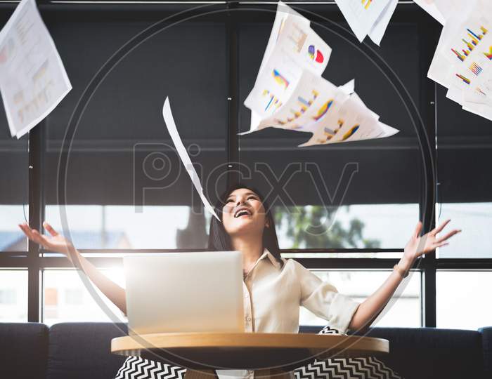 Asian Businesswoman Throwing Paperwork Into The Air. Successful And Achievement Concept. Business And Occupation Concept. Freelance And Business Owner Theme.