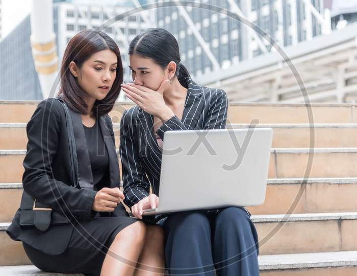 Business Women Gossip While Using Laptop At Outdoor. Business And Coworker Concept
