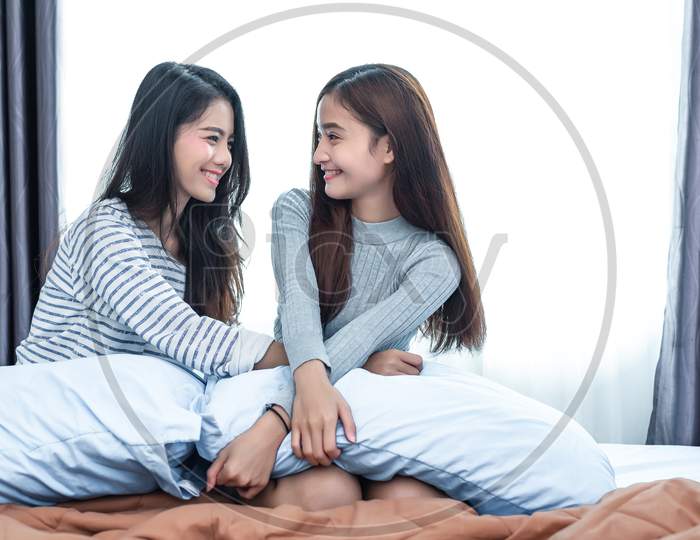 Two Asian Lesbian Women In Bedroom. Couple People And Beauty Concept. Happy Lifestyles And Home Sweet Home Theme. Cushion Pillow Element And Window Background.