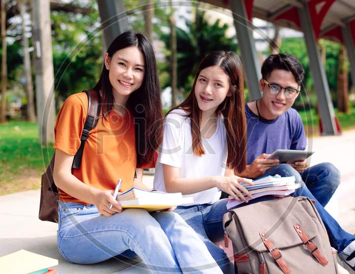 Three Young Asian People Studying Together At Outdoors. Education And Technology Concept. Lifestyles And Happy Life In Classroom Theme. People And Leisure Theme. Back To School
