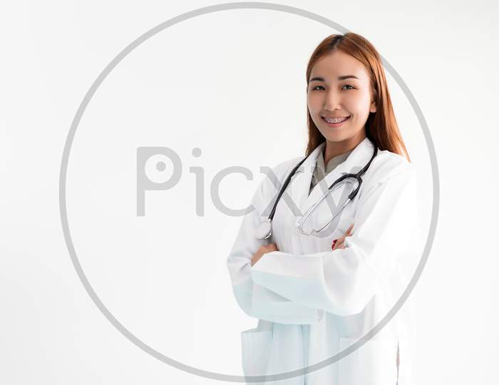 Asian Woman Doctor Is Standing Arms Crossed With Stethoscope On White Background. Medical And Healthcare Concept. Hospital And People Theme.