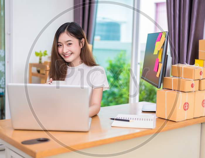 Asian Woman Enjoy Herself While Using Laptops And Internet In Office. Business And Marketing And Part Time Concept. On Line Shopping And Business Success Theme. Happy Mood Doing Working Job.
