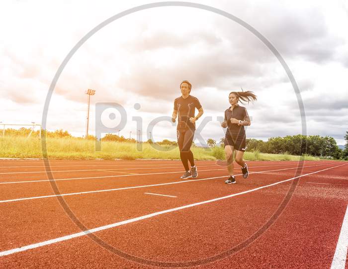 Two Runners Jogging On The Race Track, Sport And Social Activity Concept