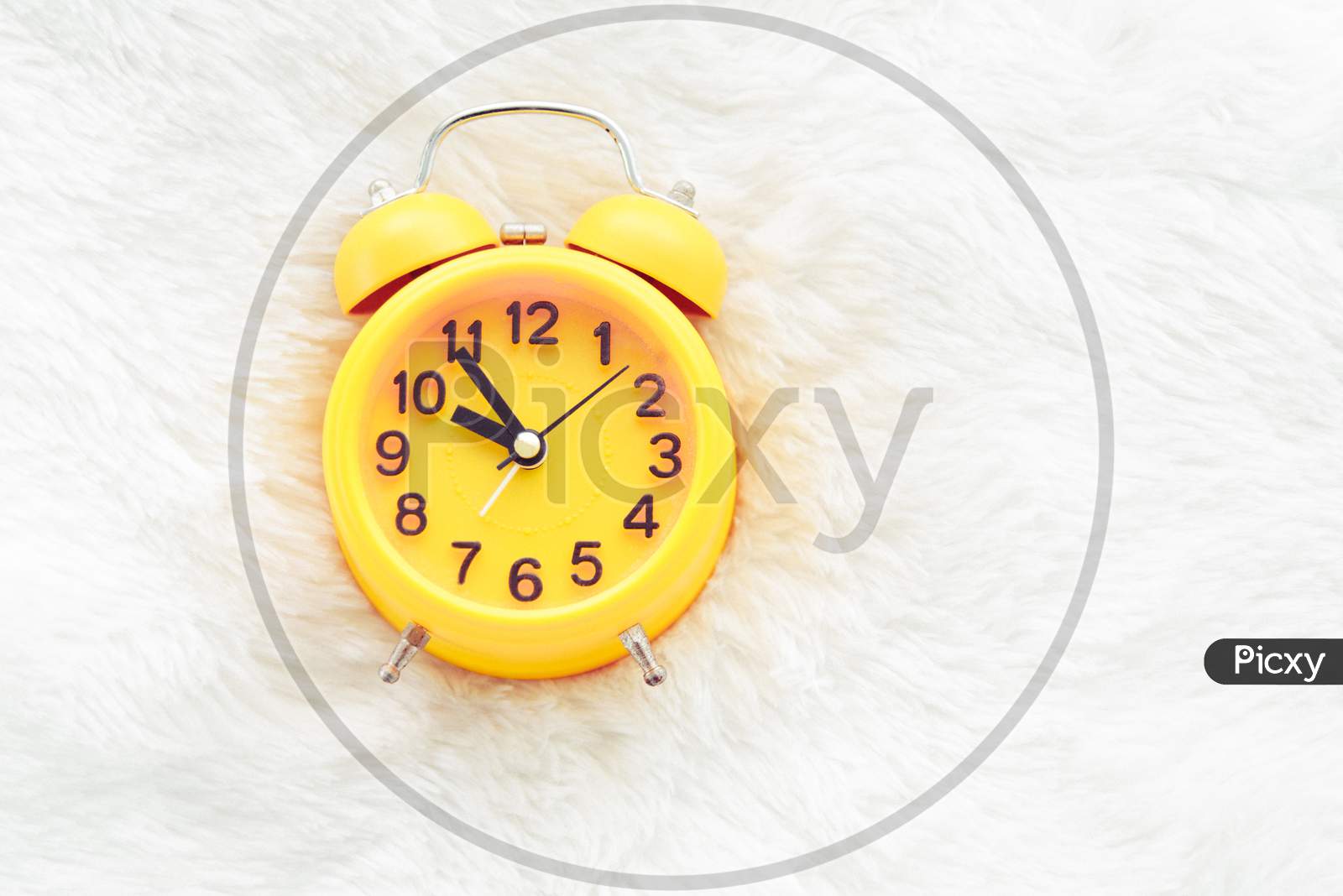 Yellow Alarm Clock On White Wool. Late And Lazy Time Concept. Morning In Holiday Theme. Around 10 O Clock
