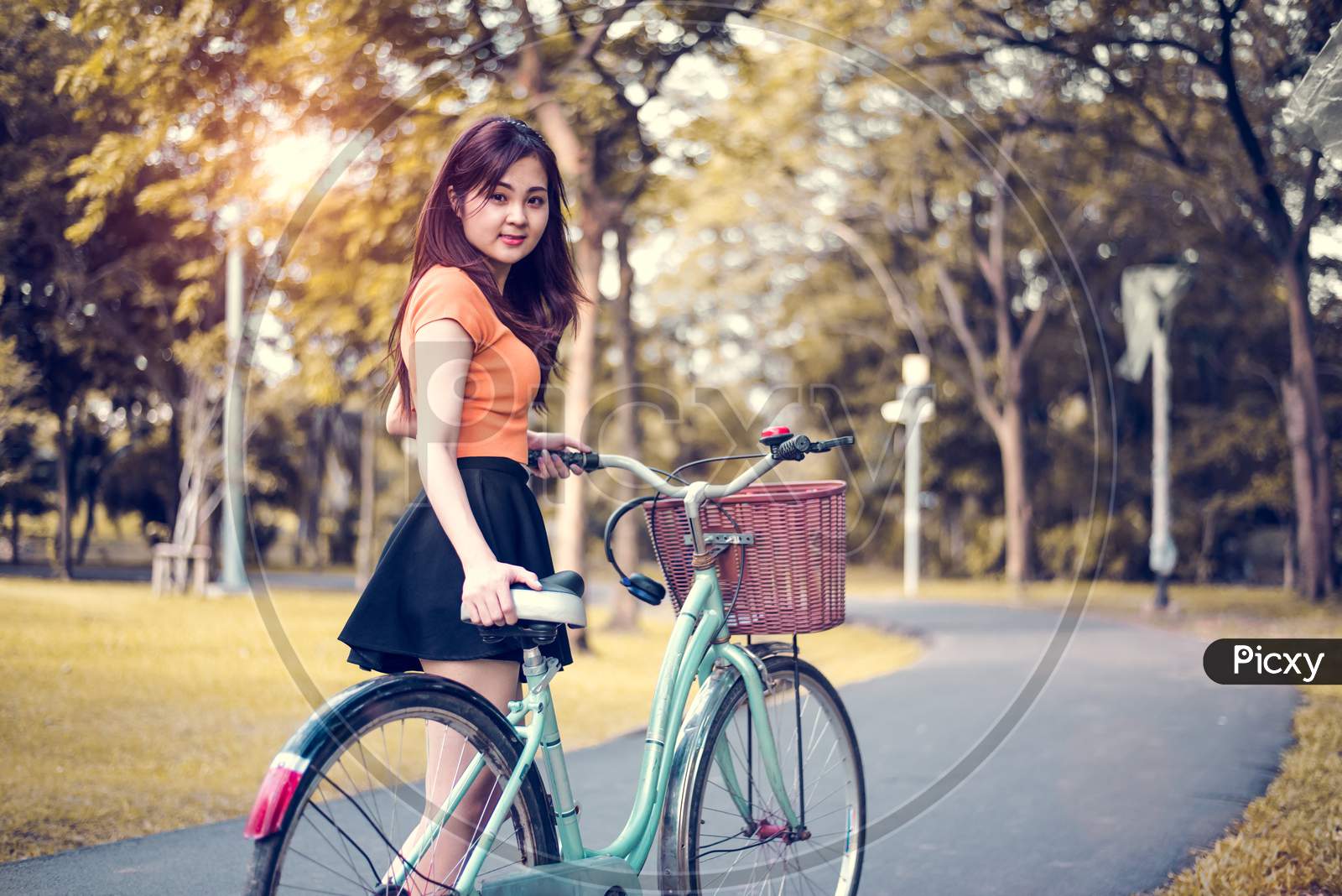 Asian Woman Portrait In Public Park With Bicycle. People And Lifestyles Concept. Relaxation And Activity Theme.