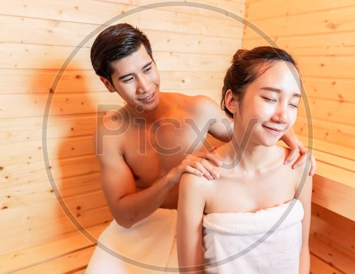 Young Asian Couples Have Romantic Relaxing Massage In Sauna Room. Skin Care Heat Treatment And Body Clean Up And Refreshing In Spa Steam Bath. Healthy And Honeymoon Concept. Happiness Valentines Day