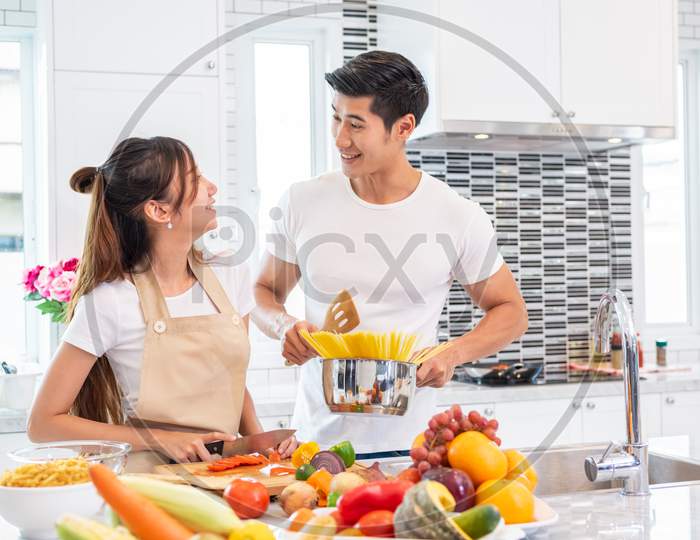 Happy Asian Young Married Couple Prepare For Making Spaghetti Bolognese In Kitchen. Boyfriend And Girlfriend Cooking Together. People Lifestyle And Romantic Relationship Concept. Valentines Day Indoor