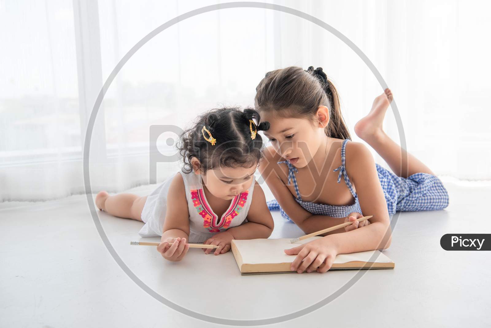 Happy Two Sister Drawing In Sketch Book Together At Home. People Lifestyle And Kids Play. Education And Children Concept. Diverse Ethnicities And Ages