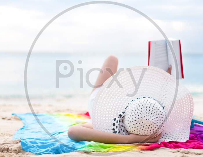 Asian Woman Sun Bathing And Reading Books In Holiday At Beach. Beauty And Nature Theme. Ocean And Sea Background. Woman Day And Relaxation Theme