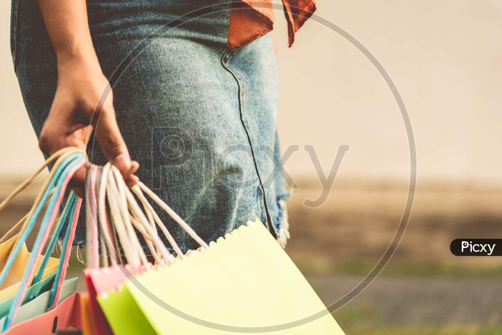 Closeup Of Woman Holding Color Paper Shopping Bag At Street. Summer Sale And Black Friday Shopping Concept. Vintage Tone Film In Cover Size Photo.