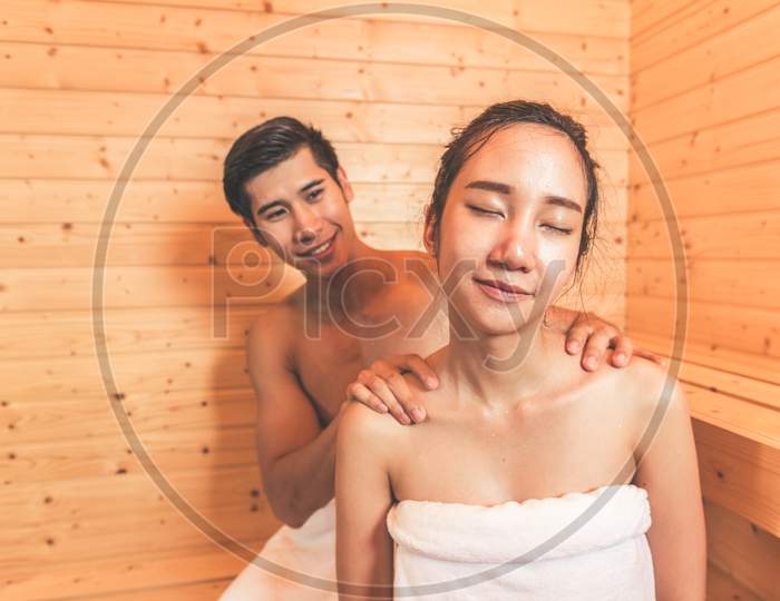 Young Asian Couples Or Lovers Have Romantic Relaxing In Sauna Room. Skin Care Heat Treatment And Body Clean Up And Refreshing In Spa With Steam Bath. Healthy And Honeymoon Concept. Happiness Together