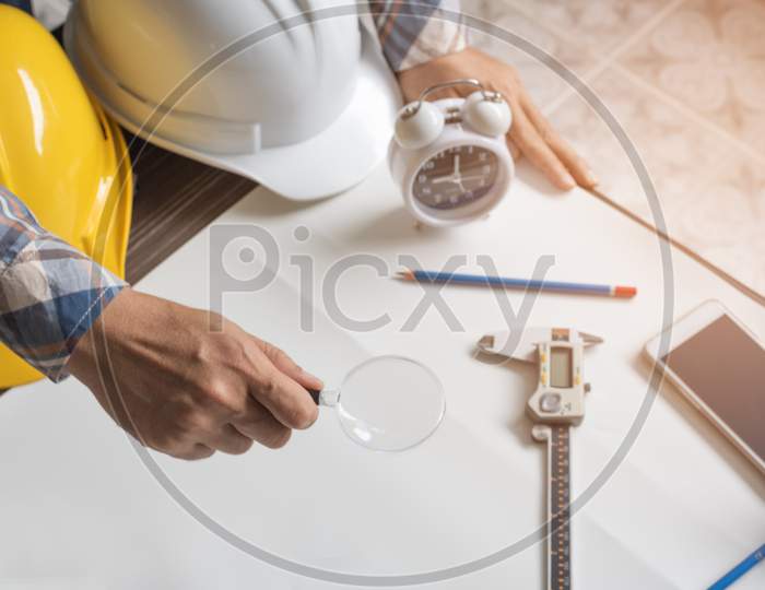 Engineer With Magnify Glass For Looking Blank Paper For New Project. Engineer And Architecture Concept, Business Theme.