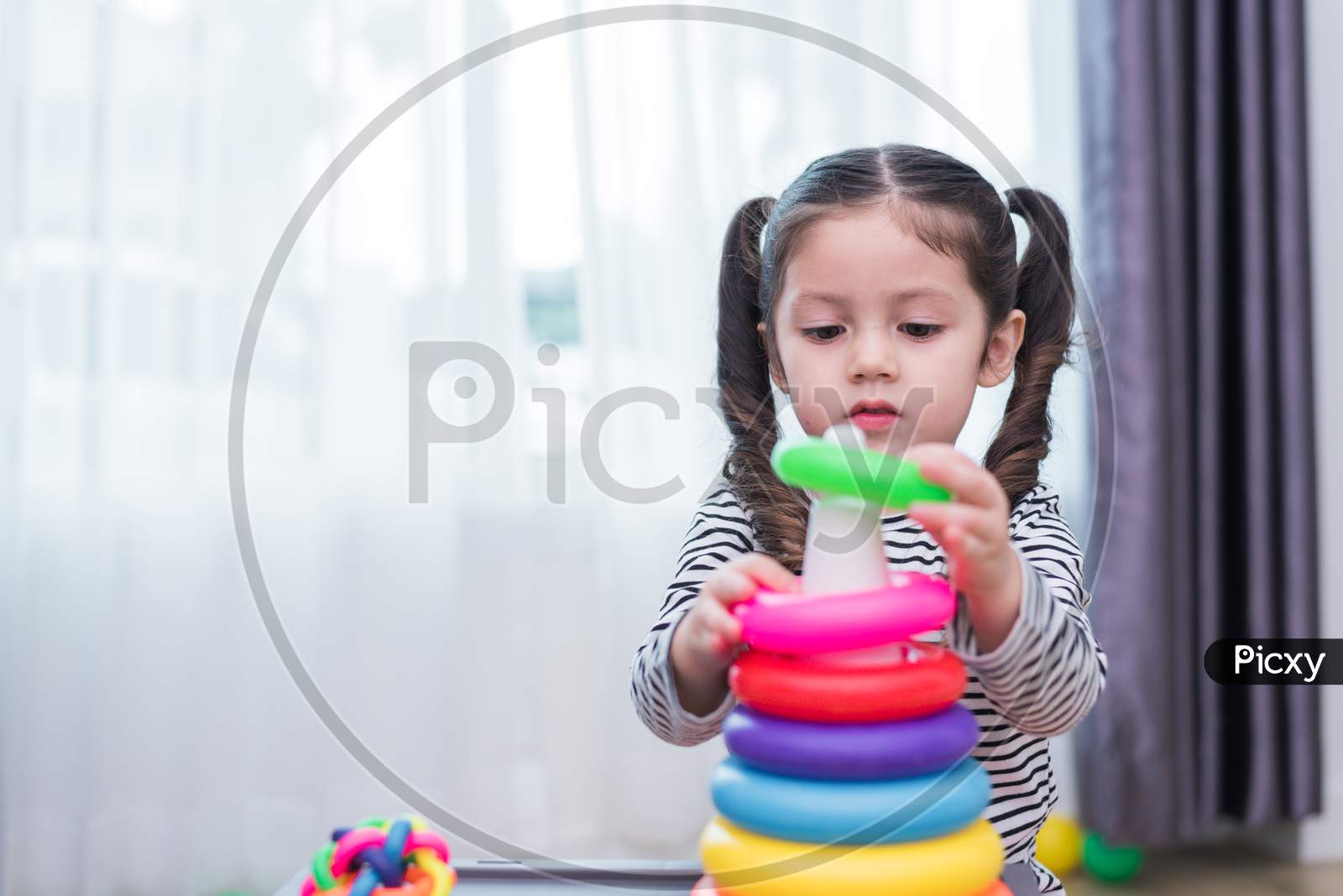 Little Girl Playing Small Toy Hoop In Home. Education And Happiness Lifestyle Concept. Funny Learning And Children Development Theme.