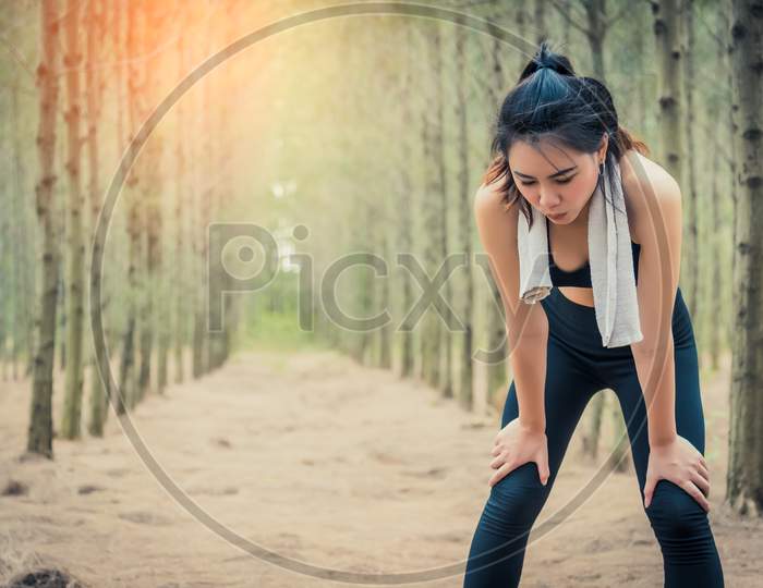 Asian Beauty Woman Tiring From Jogging In Forest. Towel And Sweat Elements. Sport And Healthy Concept. Jogging And Running Concept. Relax And Take A Break Theme. Outdoors Activity Theme.