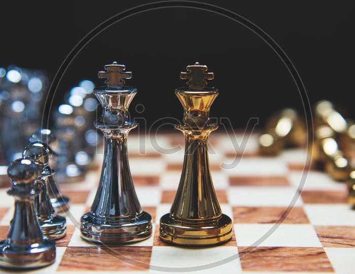 Strategy Of Leadership As King Facing Each Other In Wooden Chess Board In Checkmate Position. Business Marketing Of Competition Trade Partners Tactics Fighting Concept On Black Background