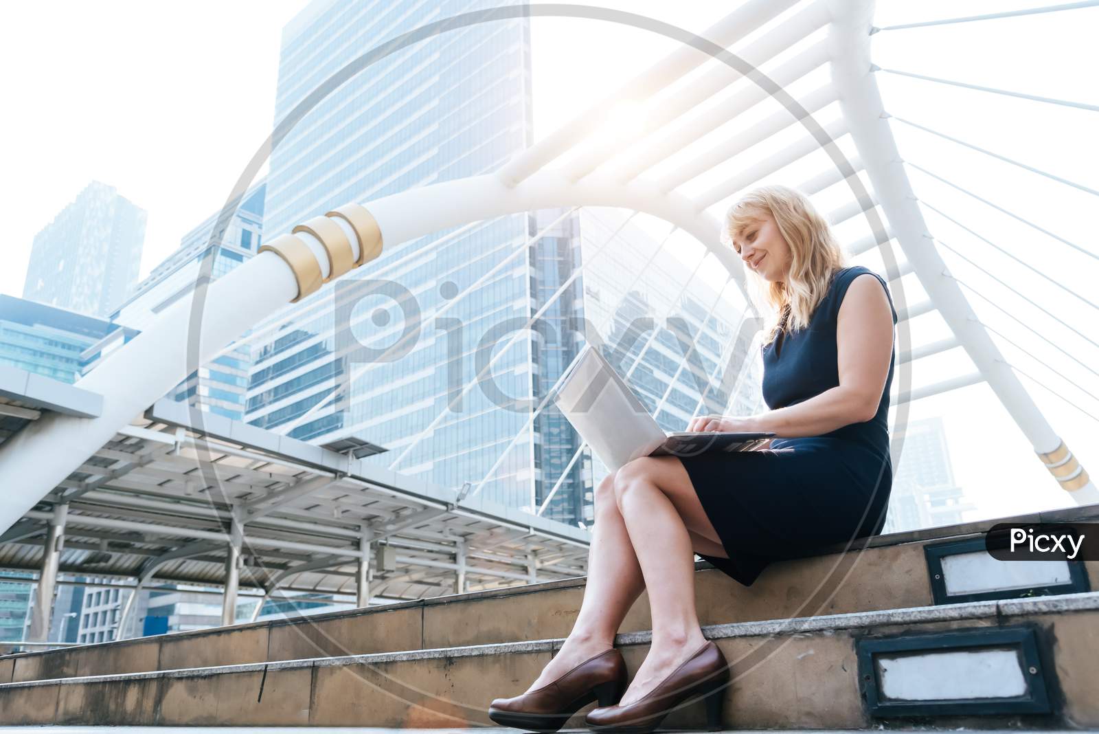Business Woman Working With Laptop At Outdoors. Technology And Happiness Concept. Beauty And Lifestyle Concept. City And Urban Theme. Blonde Hair Woman Using Computer