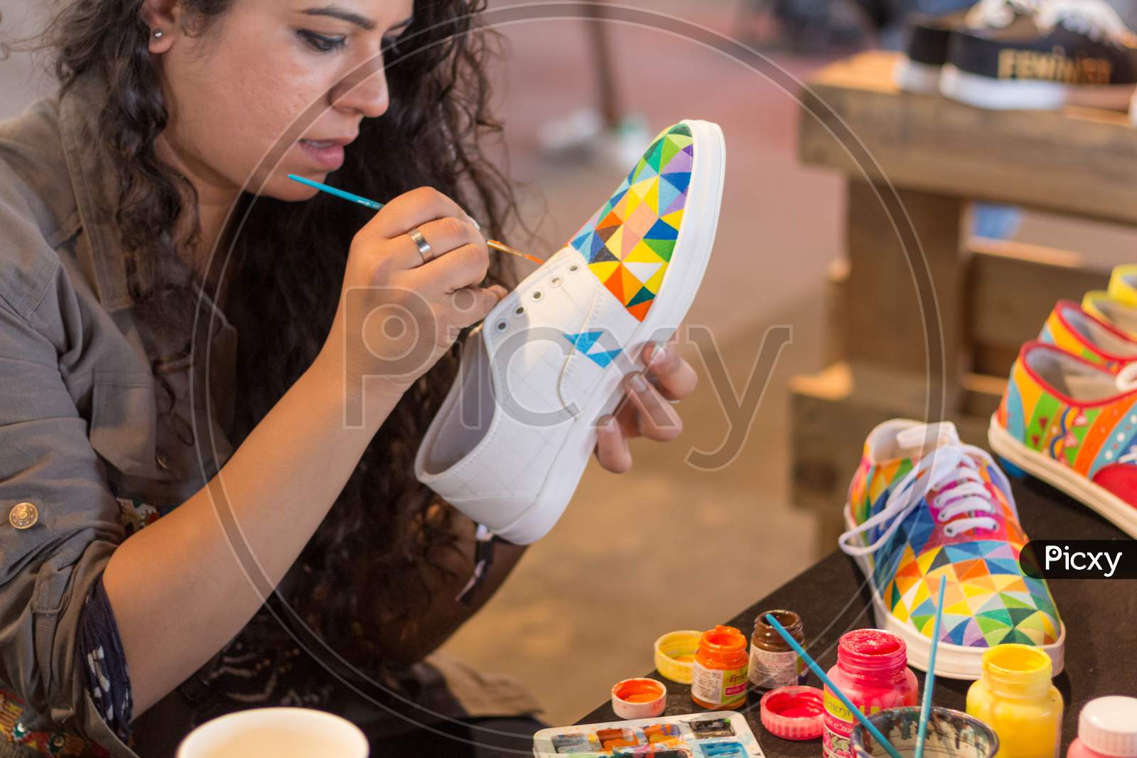 A Female Designer Painting A Shoe.