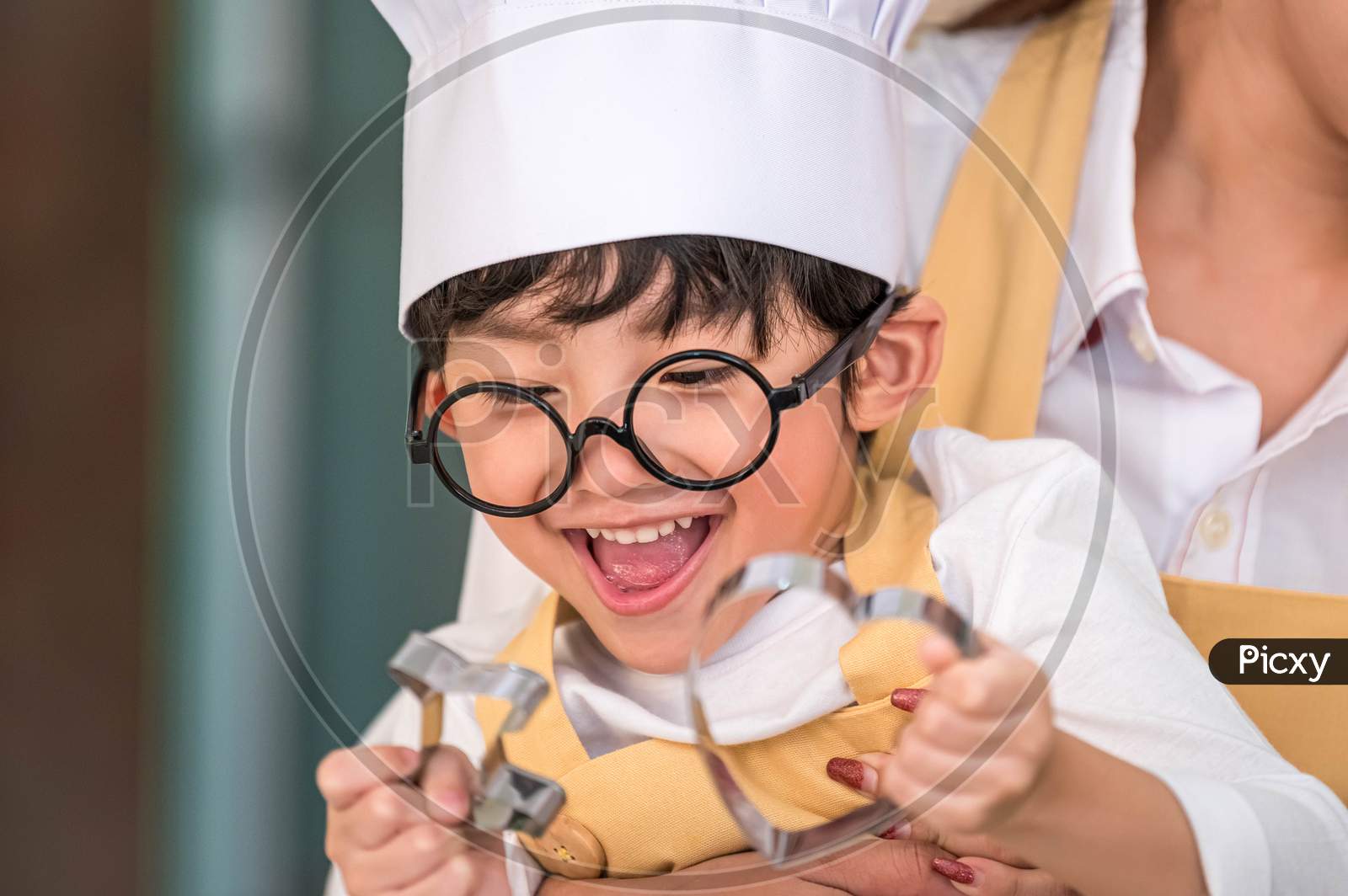 Cute Little Asian Happy Boy Interested In Cooking With Mother Funny In Home Kitchen. People Lifestyles And Family. Homemade Food And Ingredients Concept. Two People Baking Christmas Cake And Cookies