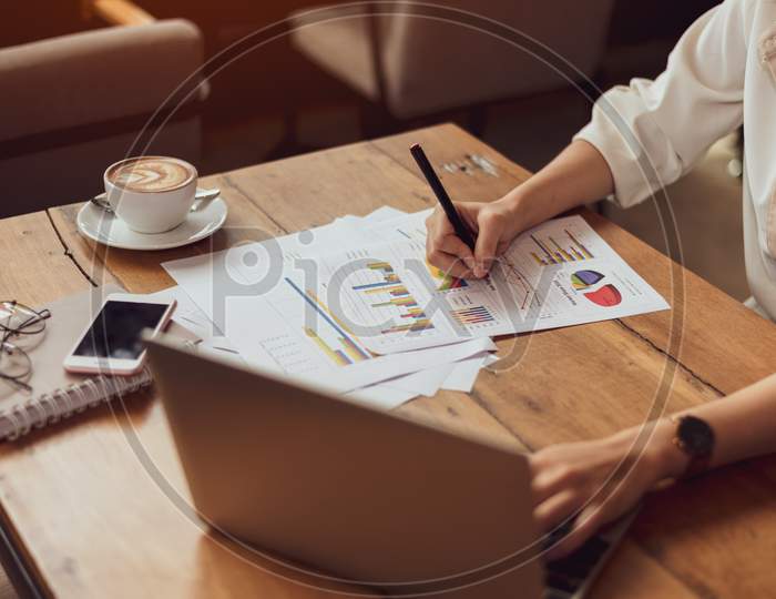 Close Up Of Business Woman Working With Documents And Laptop In Office. Business And Lifestyles Concept. Entrepreneur And Freelance Theme.