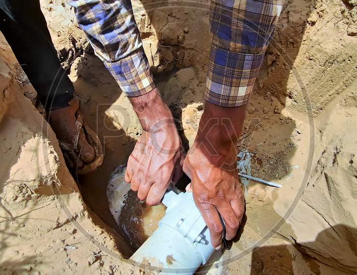 A Person Making New Water Connection From Main Supply Pipe Line Of Municipality