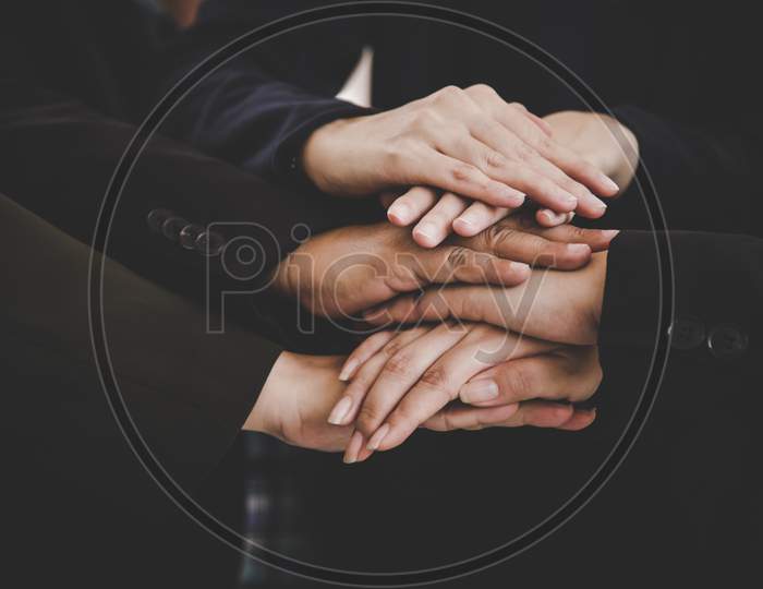Business People Making Pile Of Hands For Startup New Project. Business And Togetherness Concept. Cooperation And Successful Concept. Teamwork And Organization Theme. Close Up View Of Stacking Hands.